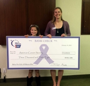 Presley McLain, 9 years old, holds a check in the amount of $3,038 which she raised for the ACS.
