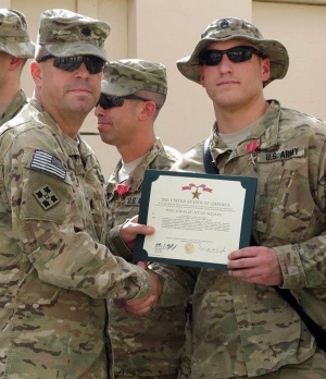 United States Army Staff Sergeant Kevin J. Buddy Edwards holds his Bronze Star Medal Certificate.