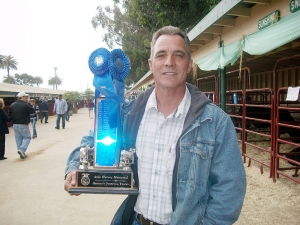 Fillmore FFA Advisor Mr. Joe Ricards holding the perpetual trophy for the Herdsmanship Award.