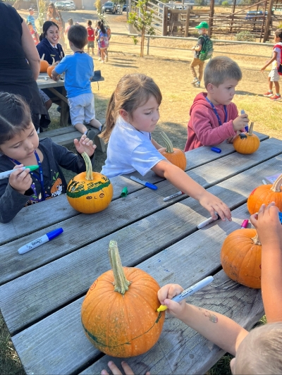 Kindergartners decorating their own special pumpkins to take home to their friends and family.