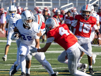 Above, a JV Flashes player carries the ball past the Hueneme defense. Photo credit Crystal Gurrola.