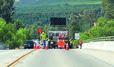 On Friday, September 13, 2024, traffic was delayed for work on Old Telegraph Road which was closed down to one lane due to the Ventura County Transportation Commission doing emergency repairs on the embankment along the Sespe Creek.  Photo credit Angel Esquivel. Inset photo Gazette staff.