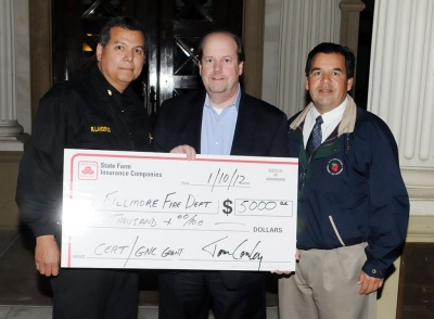 Fillmore Fire Chief Rigo Landeros, State Farm Public Affairs Official Greg Sherlock, and Asst. Fire Chief Bill
Herrera hold a $5,000 check, presented to the Fillmore Fire Dept. for the C.E.R.T. program and equipment and training. The grant was presented by State Farm Insurance.