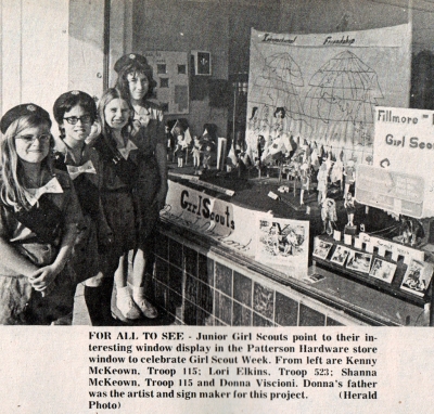 Article from the Fillmore Herald March 16th 1972 reading “The Junior Girl Scouts point to their interesting window display in the Patterson Hardware store window to celebrate Girl Scout Week. From left are Shanna KcKeown, Troop 115; Lori Elkins, Troop 523; Shanna KcKeown, Troop 115 and Donna Viscioni. Donna’s father was the artist and sign maker for this project. (Herald Photo).
