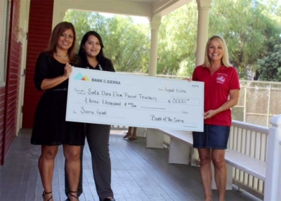 Jennie Andrade, Assistant Vice President, Fillmore Branch, and  Adriana Mejia, the Financial Service Representative of the Fillmore Branch presented the check to Kari Skidmore, Principal.