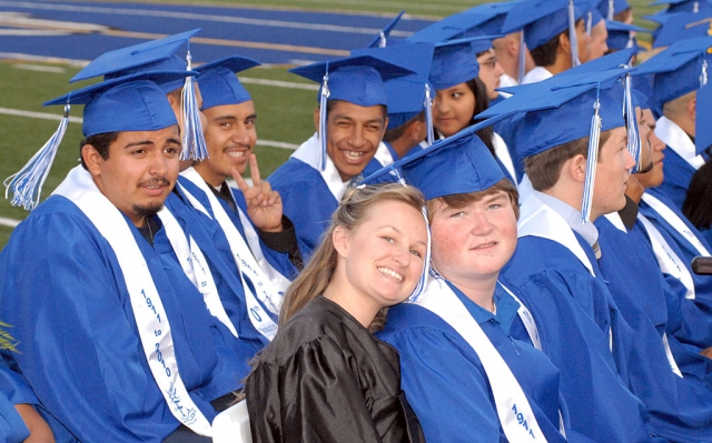 Several graduates patiently wait for their names to be called to receive their diplomas. Pictured front is Chelsea Dryer who accompanied her brother Jake to his graduation.