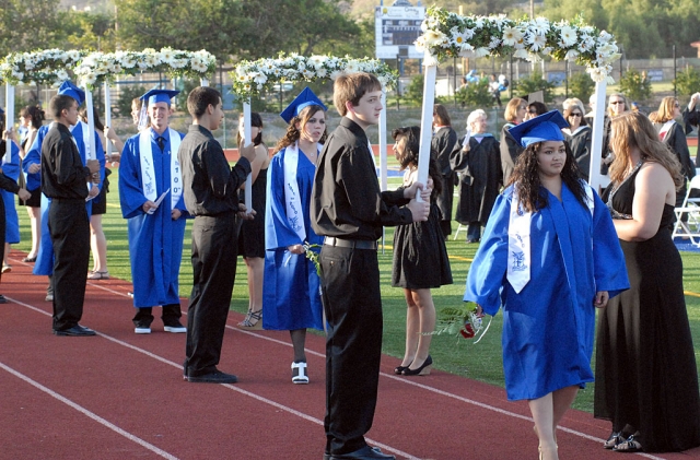 Fillmore High School graduates walk under the traditional arches held by the junior class.