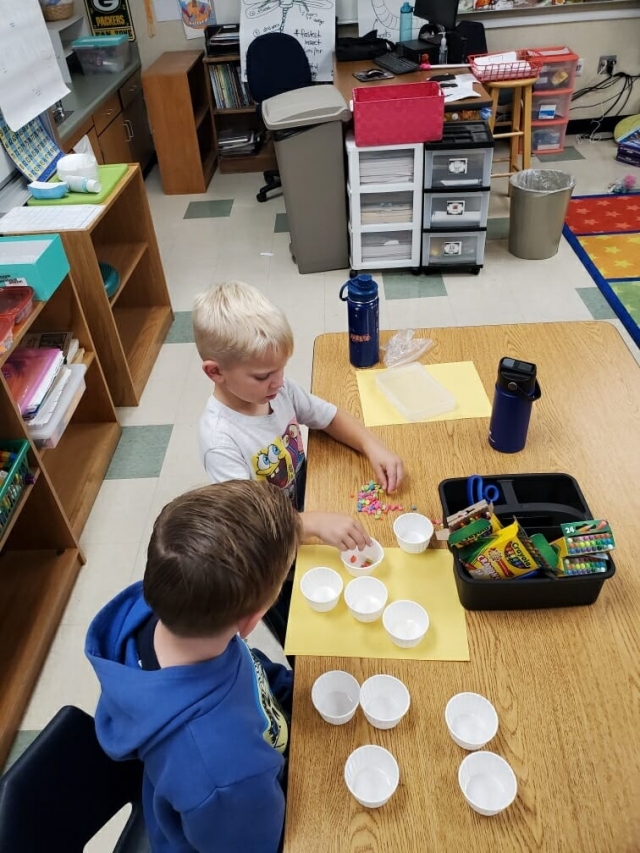Summer School is in session at Mountain Vista, pictured above and below are 1st graders having fun as they discuss counting strategies with Counting Collections during Summer School. Courtesy https://www.facebook.com/permalink.php?story_fbid=pfbid0EBYbTsgK3S4q8qrnwr rFZ19vdncmgMVd2SYfkeuP5s9pBDx8fATxg8 moaQmur7jMl&id=100063493185283.