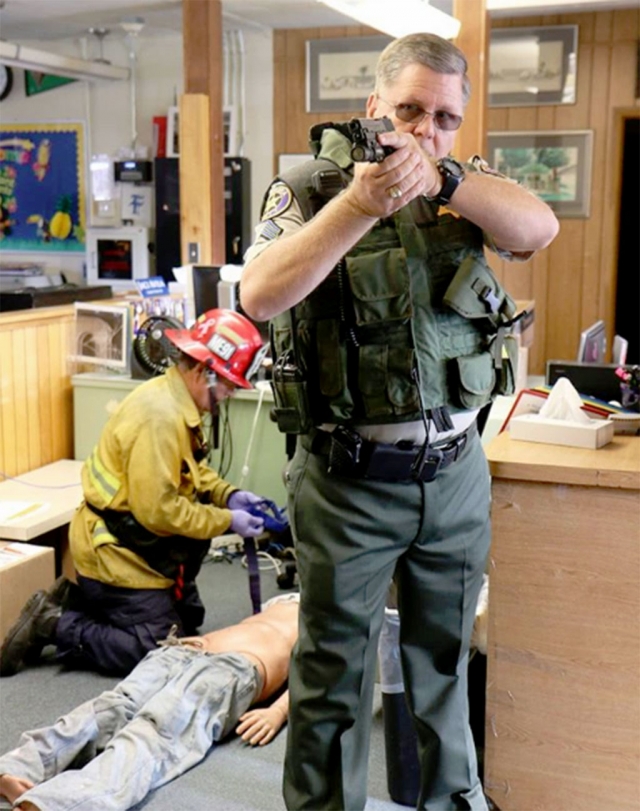 [Courtesy Capt. Eric Tennessen] For a few hours early in the morning on Monday, August 13th, gunshots and the screams of teenagers echoed through the hallways of Fillmore High School.  Thankfully, school is not yet in session and this was part of an organized Active Shooter training for Fillmore deputies, School Resource Officers from throughout our agency, the Fillmore Fire Department and faculty and staff from Fillmore High School.  Fillmore’s Police Explorers provided a realistic feel to the training, feigning injuries while running and screaming through the hallways and around the campus. During the training, responding deputies were required to search classrooms, locate and neutralize an active shooter roaming on the campus.  At the same time, deputies teamed with members of the Fillmore Fire Department to utilize the rescue task force concept by providing treatment to victims in the area of the shooting.  Finally, the Active Shooter training staff conducted separate classroom and scenario training for more than one hundred faculty and staff members from the Fillmore Unified School District. This scenario-based training placed extra effort into heightening the realism of the training experience for all of the participants.  Utilizing blank ammunition and actors to the training gave participants a chance to perform under stress and build confidence in their decision-making process. Fillmore School District Superintendent Adrian Palazuelos was especially grateful for the value of the training in providing a new level of awareness to his staff.