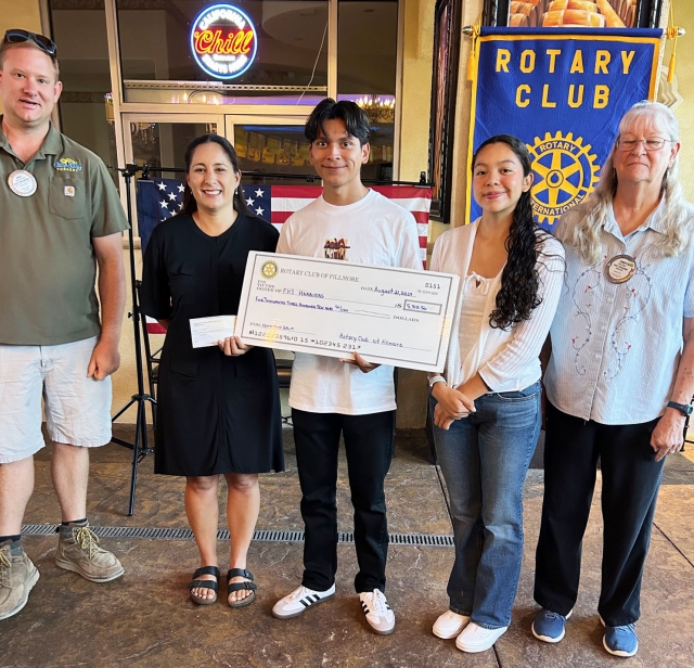 On Wednesday, August 21, Rotary Club of Fillmore recognized Kim Tafoya, a coach for 22 years, and two of her players, FHS Seniors Harriers Omar Heredia and Diana Santa Rosa were the Rotary program speakers. Kim and her students worked on and at the 5/10K Run Fundraiser.  They split the profits of the event and Cindy Blatt and Andy Klittich presented them with a check for $5,310.56. Pictured (l-r) are Andy Klittich, Kim Tafoya, Omar Heredia, Diana Santa Rosa and Cindy Blatt. Photo credit Martha Richardson.