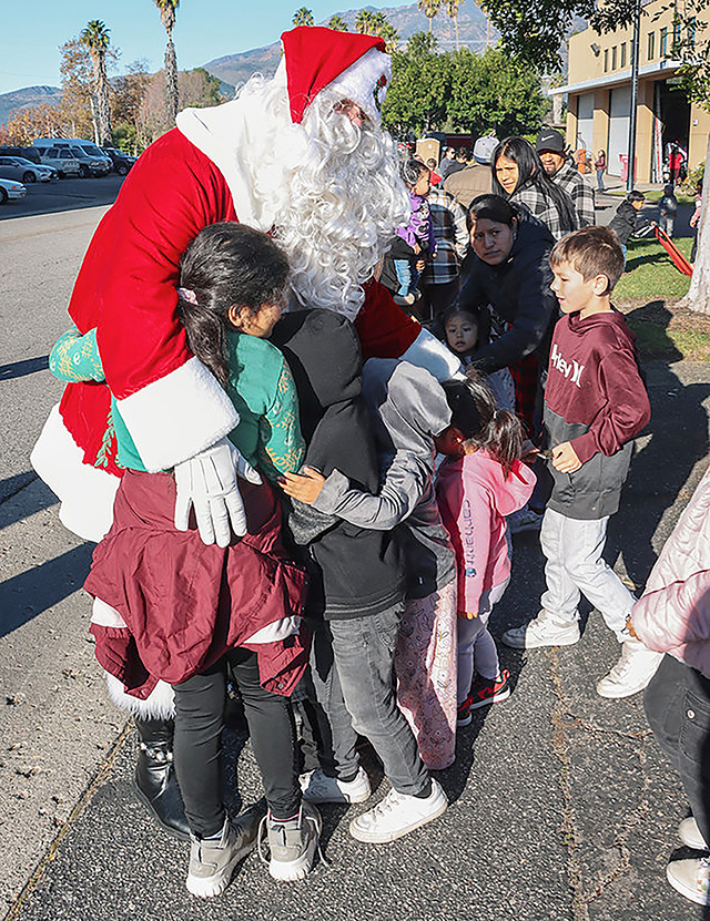 Saturday, December 13, was the annual Fillmore Community Holiday Giveaway. From 9am to 12pm, families lined up at the City of Fillmore Fire Station at 711 Landeros Lane for the event as Santa arrived on Fire Engine 91 to greet everyone patiently waiting. The crowd received age-appropriate toys, new jackets/coats, reading books and socks. As is customary, a holiday bag of groceries were available for each family while supplies lasted and Santa Claus was available for a picture with each child. This year’s sponsors of the event included our local Fillmore Police and Fire Departments, Santa Clara Valley Legal Aid, One Step A La Vez, Soroptimist International of Fillmore, Rotary International of Fillmore, Fillmore Lions Club, Ventura County Deputy Sheriff’s Association, Fillmore Citizen’s Patrol, Fillmore Friends of the Library, Super A Grocery, Estrella Market, Salvation Army, the Fillmore Fire Foundation and numerous other generous individual and business donors. Photo credit Angel Esquivel. 