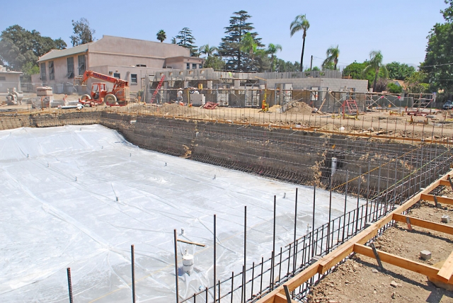 The concrete floor of the swimming pool has been poured. It is now covered with a plastic sheeting in order to facilitate curing.