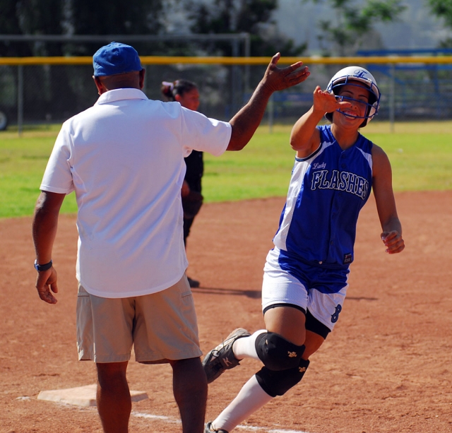 Nadia Lomeli high fives Coach Ortiz rounding third base. Lomeli hit a homerun over the center field fence and scored 3 runs.