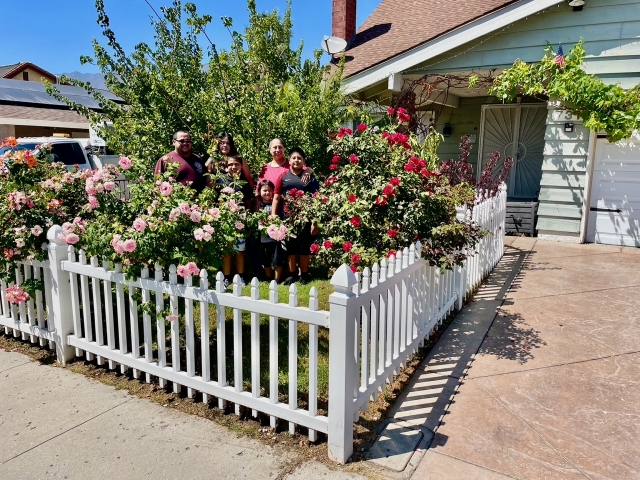 Civic Pride Volunteers named the Aguilar Family as the September 2025 Yard of the Month winners. Pictured is the family in from of their beautiful yard (l-r); Victor, Candy, Nick, Veronica, Alexis & Michael Aguilar. Inset, a deep purple shrub with beautifully shaped leaves, described by Veronica as a red blooming Hibiscus they brought from Mexico as seeds & have successfully grown. Photo credit Linda Nunes.
