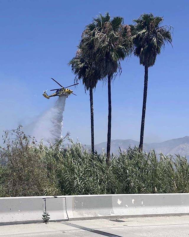 Pictured is a Ventura County Firehawk Copter making a water drop on the arson Bridge Fire on Sunday at 1:15pm. Inset, some of the manpower it takes to handle the frequent fires in the Santa Clara Riverbed. One arrest was made. Photo credit Sebastian Ramirez & Gazette staff.