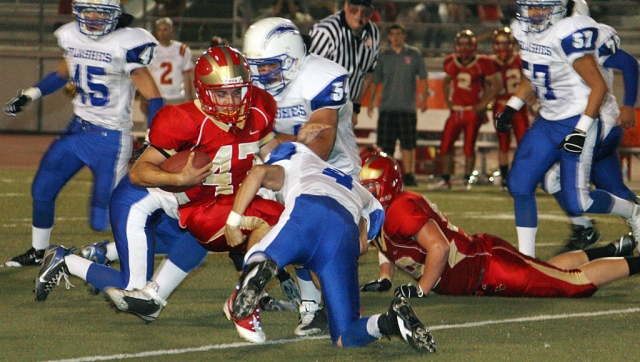 Jacob Hernandez #4 tackles the runner with the help of other teammates. Derek Luna lead the defense with 9 tackles. Fillmore lost to Village Christian 42-47.
