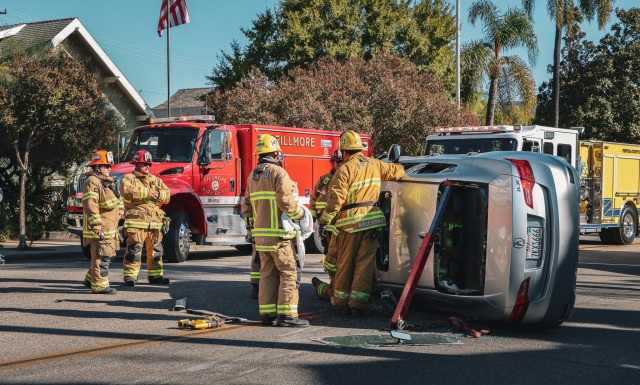 On Thursday, October 5th, at 3:46pm, Fillmore Police Department, Fillmore Fire Department, and AMR Paramedics were dispatched to a traffic collision at Central Avenue and 1st Street. Upon arrival deputies found a silver sedan flipped on its side with the female driver trapped inside. Fire personnel from Ventura County Fire and Fillmore City Fire extricated the uninjured female who was taken to a local hospital as a precaution. According to Police Chief Malagon, “The silver sedan was traveling southbound on Central Avenue approaching 1st Street. The black sedan was traveling eastbound on 1st Street and was stopped for a red traffic signal. The black sedan then made a right turn in order to travel southbound on Central Avenue and the collision occurred. Deputies did not suspect impairment by neither driver”. Photo credit Angel Esquivel- AE News. 