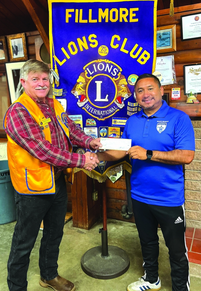 On Monday, September 18, 2023, Fillmore Lions Club President Stephen McKeown (left) presented Arnold Munoz, Regional Commissioner for Fillmore’s AYSO 242, a check for $500 in support of the ever-growing soccer program. The program has grown so quickly this year that it is now the largest youth organization in the city of Fillmore. Lions Club is proud to support the local community. AYSO is completely volunteer supported and relies heavily on the community for support. Lions Club is kicking off their pre-sale tickets for their Annual Enchilada Dinner Fundraiser. For tickets, please see a Lions Club member or contact 805-904-5424 or 805-258-3975. Photo credit Brandy Hollis.  