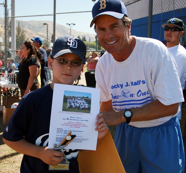 Anthony Morales wins a hand made glove from Rocky J. Hall at the closing ceremonies for Fillmore Little League.