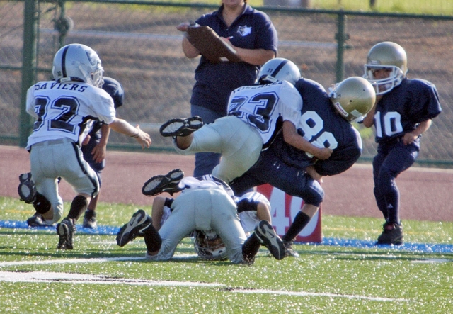 Fernando Gonzalez makes a punishing hit on a Oxnard ball carrier.