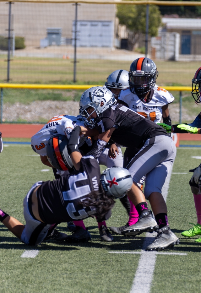 Raiders Juniors #43 & #7 team-up and make the tackle against a Simi Valley Black player in their game last Saturday. Photo credit Crystal Gurrola. 