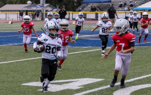 Mighty Mites Silver’s #20 blows past Valley Rush players to gain some yardage for the Raiders. Photo credit Crystal Gurrola