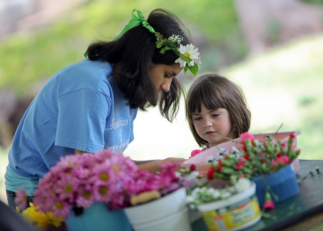 A volunteer helps a child make a flower head wreath at the Scandinavian Festival at California Lutheran University. Photo by Erik Hagen/California Lutheran University.