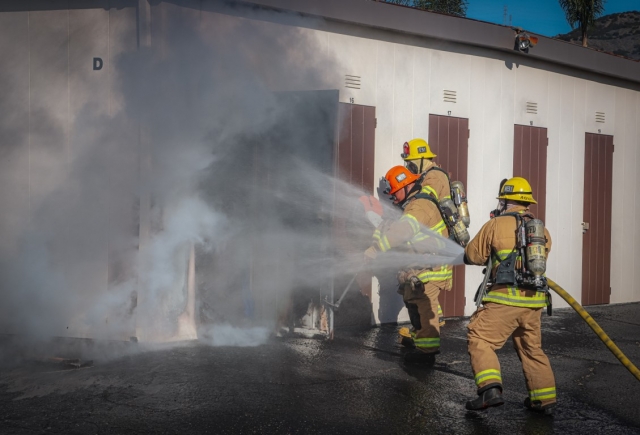 On December 9, at 1:27p.m., Fillmore Fire Department and Ventura County Fire Department were dispatched to a reported structure fire in the 200 block of Central Avenue. Arriving firefighters reported three storage units with smoke seen coming out of them. Firefighters were able to open the doors of the units and knock down the fire within minutes. Fillmore Police Dept. was also dispatched to respond to the scene for traffic control. Cause of the fire is under investigation. Photo credit Angel Esquivel-AE News.