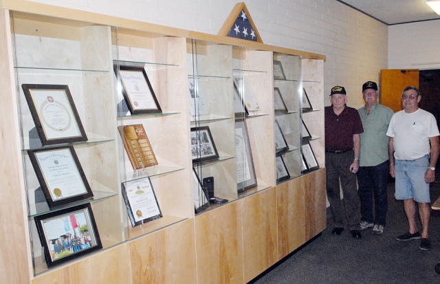 The Fillmore-Piru Veterans Memorial Building has just been enhanced by the addition of a cabinet for housing Veterans of Foreign Wars (VFW) awards and mementos. Shown here are VFW leaders John Pressey, Vic Westerberg, and Jim Rogers who have just filled the shelves with historical materials.