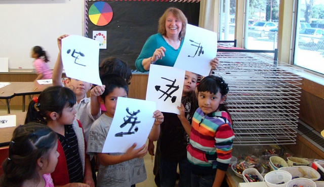 Art teacher and acclaimed local artist Virginia Neuman share some laughs with Mrs. Chambers first grade students in art class at San Cayetano.