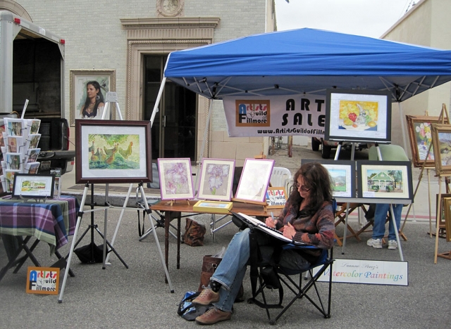 Lois Freeman-Fox added some drawings to her sketchbook during some quiet moments at this year's opening day of the Farmer's Market located at the corner of Main Street and Central Avenue, June 22. Members of the Artists Guild of Fillmore set up and opened shop under Joanne KIng's new blue pop-up canopy.  Many town residents stopped by to express their interest in the Guild's endeavors and to admire all the art on display. The Guild will to show their work at the Farmers Market every third Wednesday of the month.