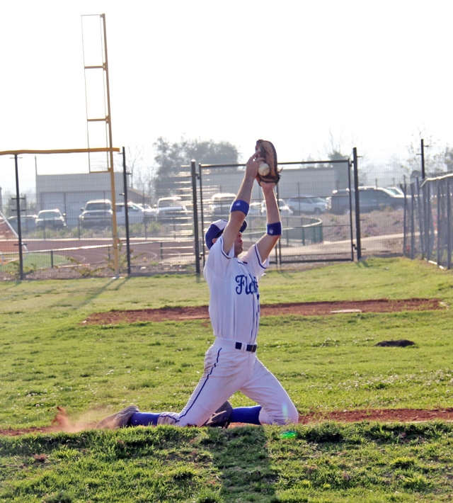 A Fillmore player doesn’t take his eye off the ball and tumbles into the warm up area for the pitchers. He caught the ball for the out.