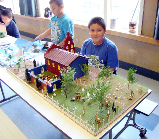 Hector Rubio sits proudly by his California Mission project.