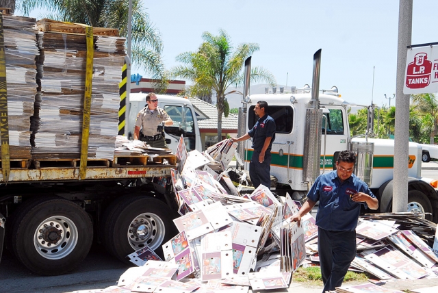 A truckload of cardboard boxes, being hauled by Standard Industires, spilled off this truck last week on Highway 126 at A Street. Officer Biter, left, stopped to help the drivers.