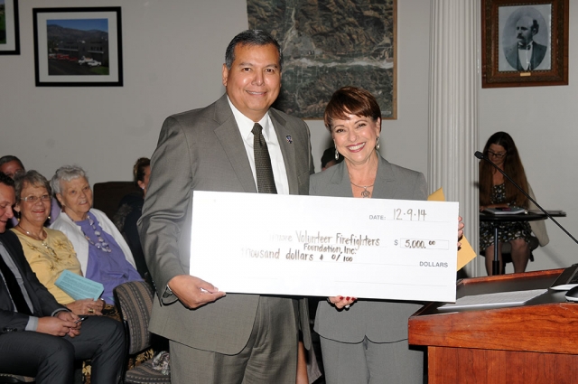 Fillmore Volunteer Fire Chief Rigo Landeros accepts a check for $5,000 from Southern California Edison Regional Manager Anna M. Frutos-Sanchez at Tuesday night’s council meeting.