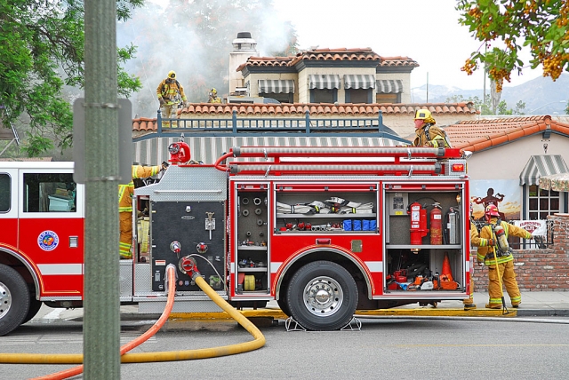 A crowd gathered in Central Park on Monday, August 3, to watch the Fillmore Fire Department and supporting units fight a fire at a popular restaurant. At approximately 9:55a.m. the City of Fillmore Fire Department responded to a report of a kitchen fire at Diamond Dave’s Cafe located at 454 Santa Clara Avenue, Fillmore. Upon arriving on scene firefighters observed heavy smoke from the rear entrance and rooftop of the structure. Shortly after entering the structure, firefighters were able to launch an aggressive attack resulting in minimal damage to three rooms and the exterior of the structure. The fire was knocked down within 15 minutes of the arrival of the first unit. The restaurant was closed at the time of the incident preventing any injuries to occupants or bystanders. Additional resources from the City of Santa Paula and County of Ventura were requested shortly after the time of dispatch. The cause of the fire remains under investigation. The building is owned by Frank and Stacy Mutz and was leased by Dave Burns.