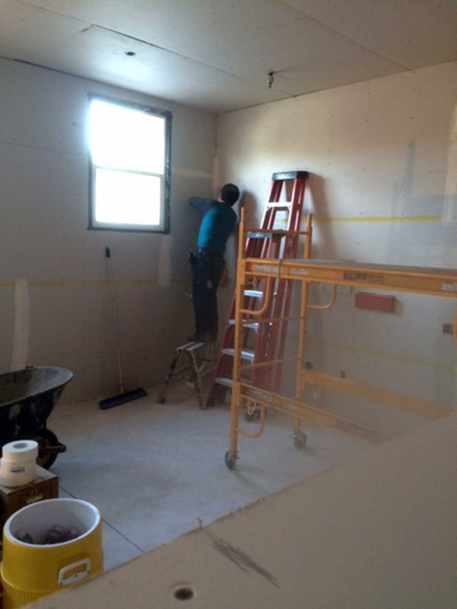 Salvador Alvardo from Local #150 applies the drywall tape, mud and texture to the so to be Teen Study Center at the Boys & Girls Club.