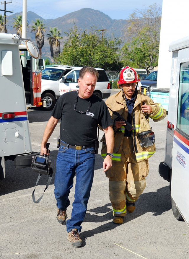Fire Captains Bob Thompson, left, and Al Huerta, head into the post office with heat sensing equipment to investigate the report of a bad smell (burning insulation) Monday, about noon. No fire was reported and a cause of the odor was not revealed at press time.