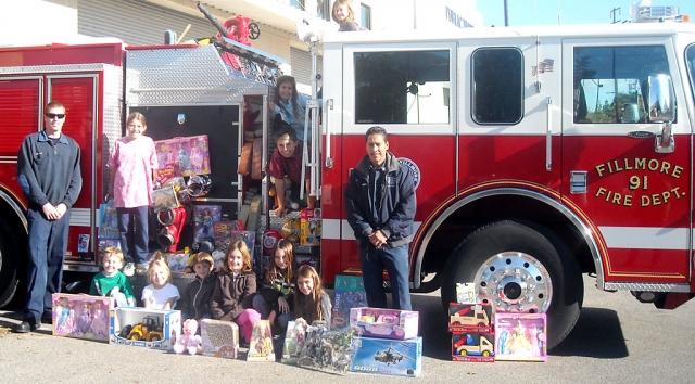 Students from San Cayetano collected items for the annual Kids Give Sale. Pictured are Chad Hope, Tori Villegas, Sara Uriel, Kasey and Dylan Crawford, Cali and Ty Wyand,  Rachel, Victoria and Julia Pace, along with Captain Al Huerta and an unknown fireman, left.