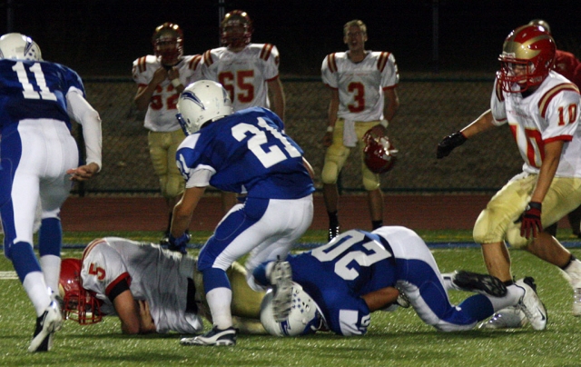 Johnny Golson #20 tackles #5 during Friday night’s game. Corey Cole #11 and Nick Paz #2 run over to assist Golson with the tackle.