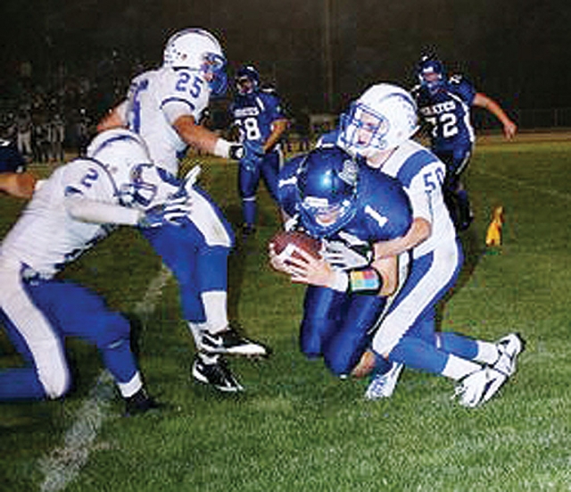 Varsity player Johnny Wilber #50, tackles Morro Bay’s quarterback on a run. Also pictured Ty Casey #2 and Austin Davis #25.