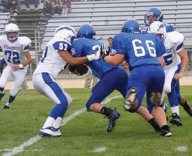 J.V. player M.J. Moreno #57 tackles the runningback.