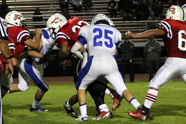 Joseph De La Mora #25 stops the runner from gaining yardage.