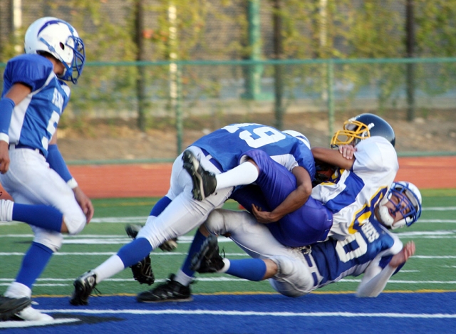 Daniel Cruz #19 (JV) helps his teammate bring a Nordoff runner down. Fillmore lost 42-0.