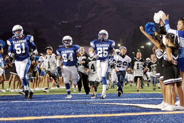 Fillmore Flashes held Raider Night at last Friday night’s game. The little guys were able to run out on the field with the varsity players, and the Raider Cheerleaders were on the field as well. Varsity Football Re-cap: Nathan Ibarra passed for over 150 yds and rushed for 66yds to lead the flashes past Village Christian. Christian Prado was the leading tackler with 10 tackles. “This is what the team needed more than anything, to believe that they have the ability to execute and end the game with a big win”, according to Coach Dollar. (All photos courtesy Mike Watson)