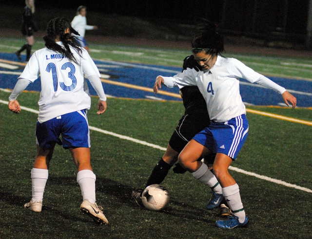 Princess Vaca #4 fights for the ball against Oak Park, her teammate Luz Morenes come to assist.