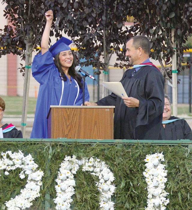 Senior Class President Miriam Hurtado waves her arm to get the crowd excited before her speech.