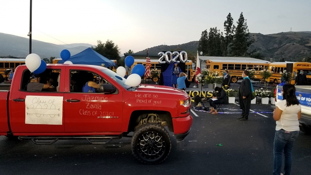 On June 4th Fillmore High held a Graduation Procession to celebrate the accomplishments of the Class of 2020. Approximately 230 graduates drove in vehicles with their families into a decorated school parking lot complete with buses, a stage, flowers, and an American flag displayed on top of a Fillmore fire truck. Each graduate walked across the graduation stage and posed for their graduation photo with diploma in hand while their families cheered. A video of the entire Graduation Procession can be found on YouTube at https://www.youtube.com/watch?v=dIROP_M2-s8