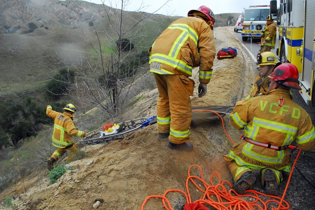A compact car crashed through a dirt berm at a sharp bend in the road at the top of Grimes Canyon, Wednesday afternoon at 12:23 p.m., landing approximately 100-feet below.