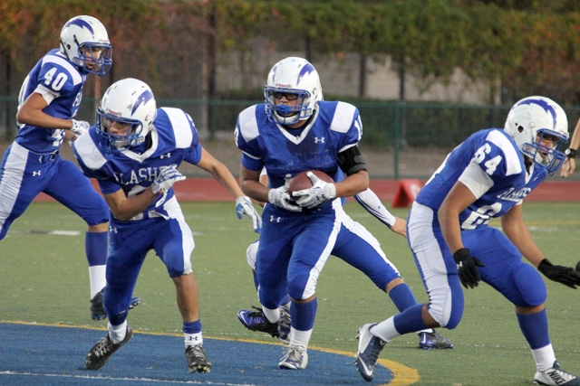 J.V. #10 Daniel Tafoya runs for a first down while gaining blocks from #5 Jose Perez and #64 Angel Medina